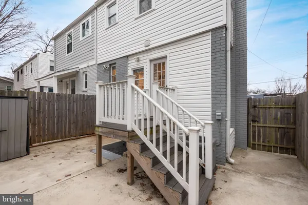 a view of a white house with a large tree