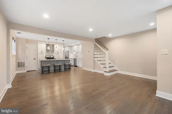 a view of a room with chairs and wooden floor