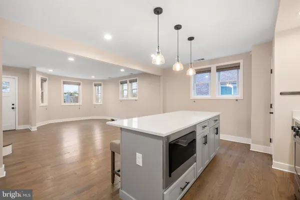 a kitchen that has a sink a stove and a wooden floor