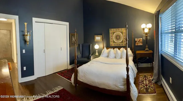 a bedroom with a bed and dresser with mirror