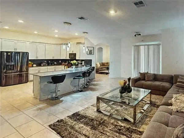 a living room with furniture and kitchen view