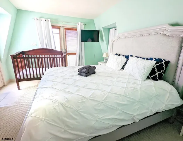 a bedroom with a bed window and a flat screen tv