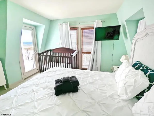 a bedroom with a bed window and a flat screen tv