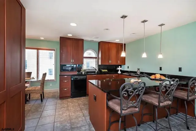 a kitchen with stainless steel appliances granite countertop a stove a sink a oven a dining table and chairs