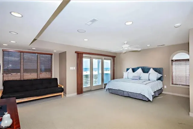 a spacious bedroom with a bed and large window