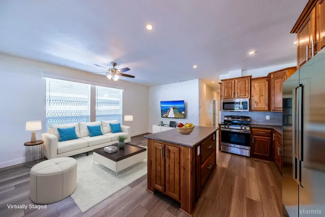 a kitchen with stainless steel appliances granite countertop a sink dishwasher stove and refrigerator with wooden floor