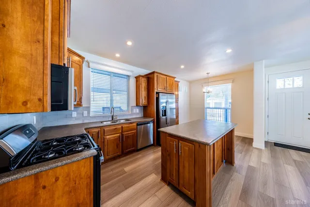 a kitchen with stainless steel appliances granite countertop a stove a sink dishwasher and a refrigerator
