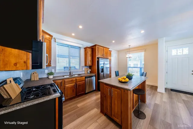 a kitchen with stainless steel appliances granite countertop a stove a sink and a refrigerator