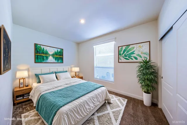 a bedroom with a large bed and a potted plant