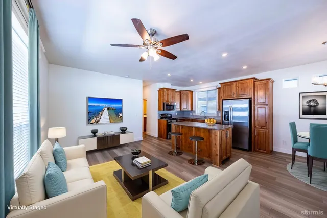 a living room with furniture kitchen view and a chandelier