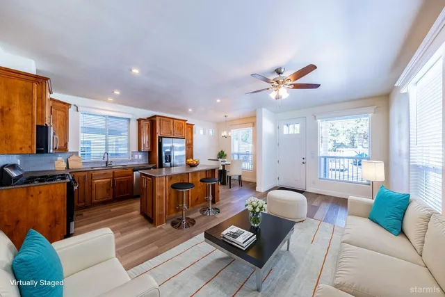 a living room with furniture kitchen view and a large window