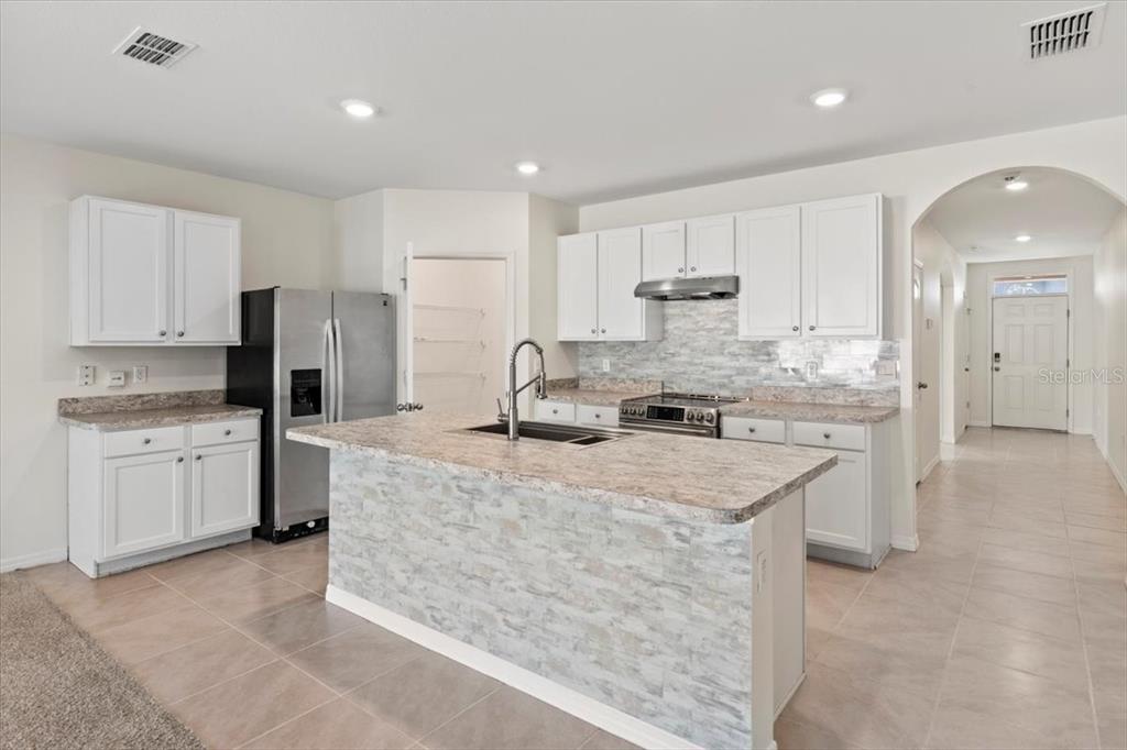 205 Old Mill Pond Road Palm Harbor, FL 34683 - Photo 15 of 57 a kitchen with kitchen island a counter top space a sink stainless steel appliances and cabinets