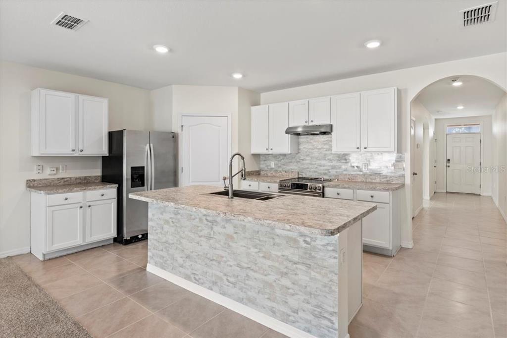 205 Old Mill Pond Road Palm Harbor, FL 34683 - Photo 16 of 57 a kitchen with kitchen island a counter top space a sink stainless steel appliances and cabinets