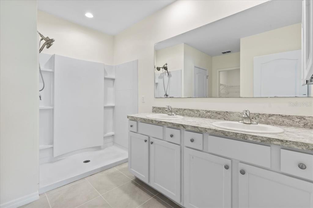 205 Old Mill Pond Road Palm Harbor, FL 34683 - Photo 30 of 57 a bathroom with a granite countertop sink mirror and shower