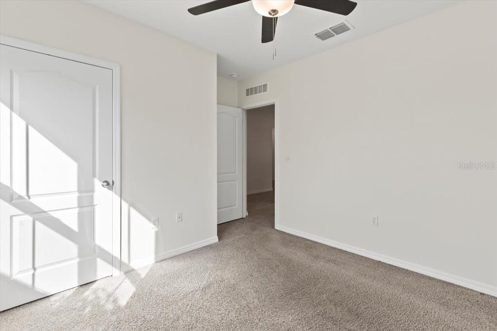 205 Old Mill Pond Road Palm Harbor, FL 34683 - Photo 6 of 57 an empty room with a ceiling fan and windows