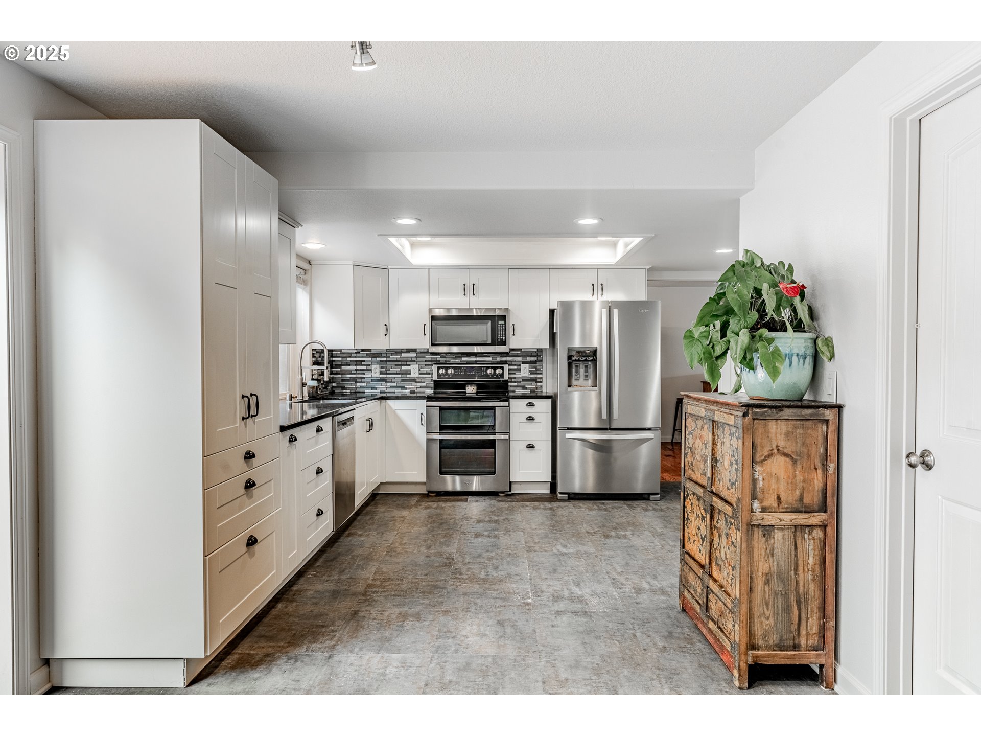 4043 Southeast Harmony Place Camas, WA 98607 - Photo 13 of 40 a kitchen with white cabinets and stainless steel appliances