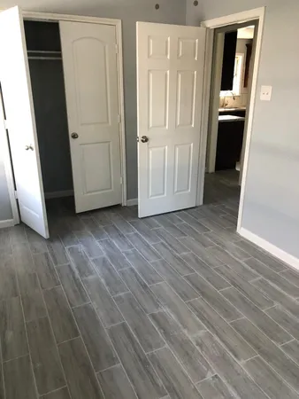 an empty room with wooden floor and entrance