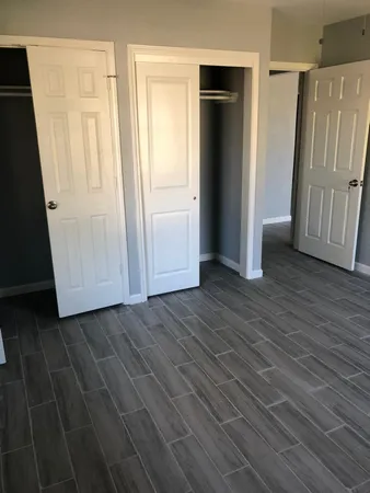 an empty room with wooden floor and a window