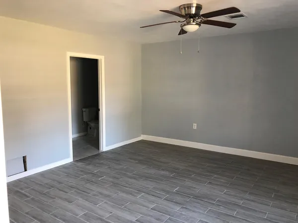 a view of an empty room with wooden floor