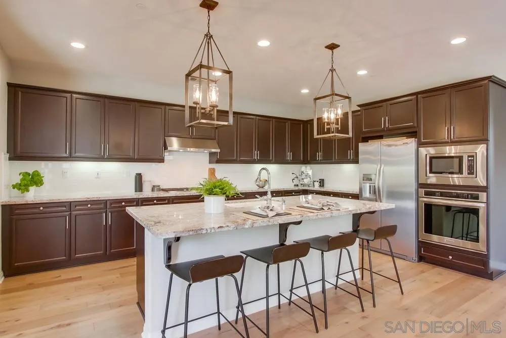 15559 Tanner Ridge Road San Diego, CA 92127 - Photo 6 of 25 a kitchen with kitchen island granite countertop a stove a sink a oven a center island and cabinets