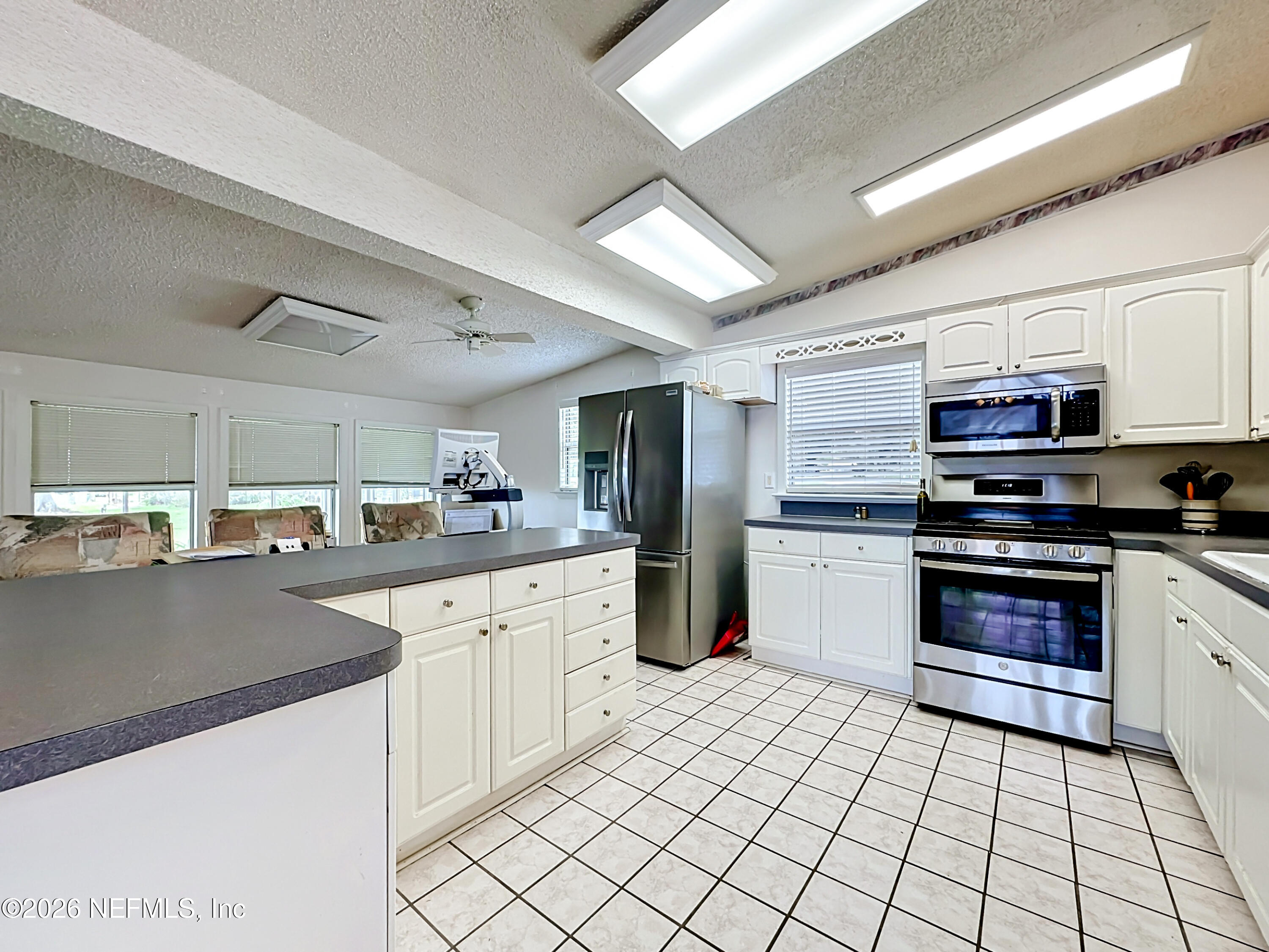 126 Pique Road Crescent City, FL 32112 - Photo 16 of 59 a kitchen with stainless steel appliances a sink counter space cabinets and a window