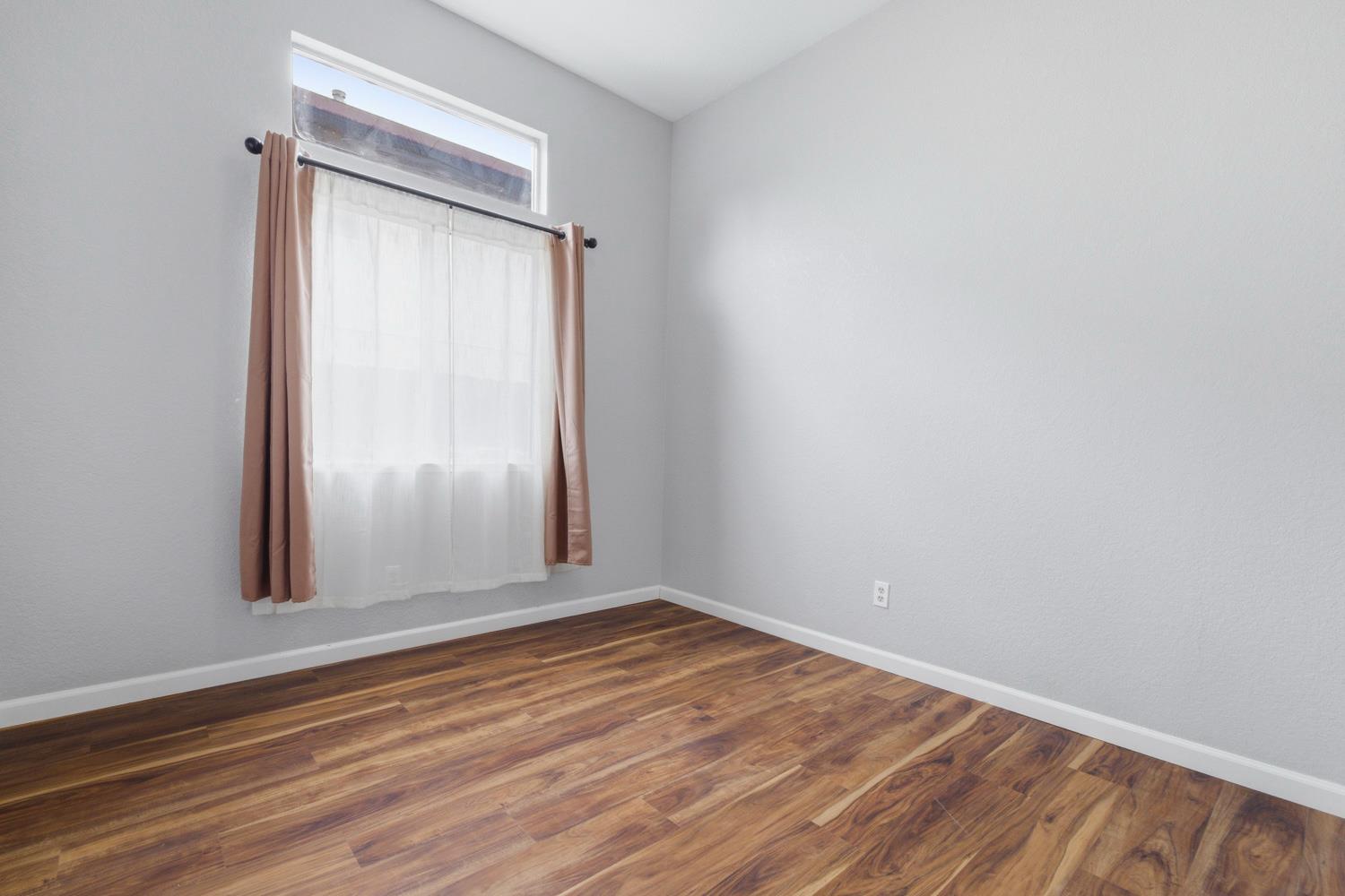969 Colson Way Galt, CA 95632 - Photo 30 of 38 a view of an empty room with wooden floor and a window