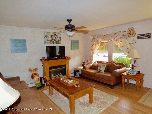410 Evergreen Drive Rifle, CO 81650 - Photo 6 of 14 a living room with furniture a flat screen tv and a fireplace