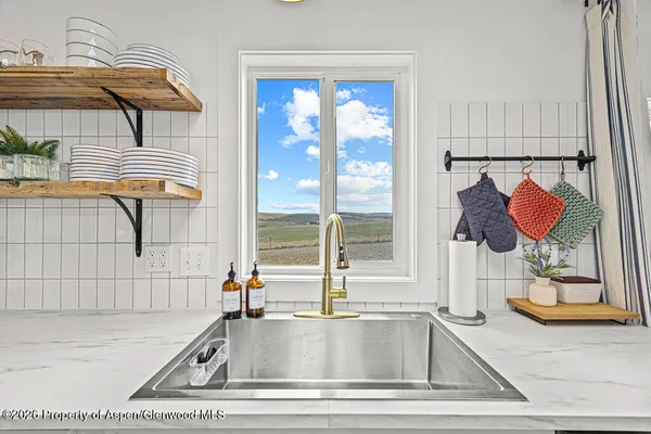 a large kitchen with stainless steel appliances kitchen island granite countertop a sink and a refrigerator