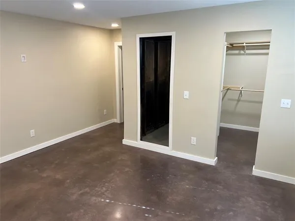 an empty room with closet and a bathroom