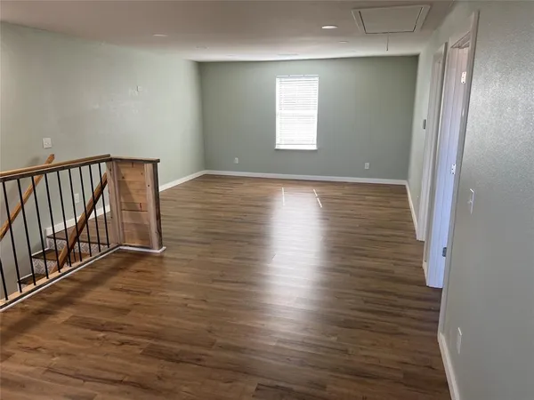 a view of a room with wooden floor and window