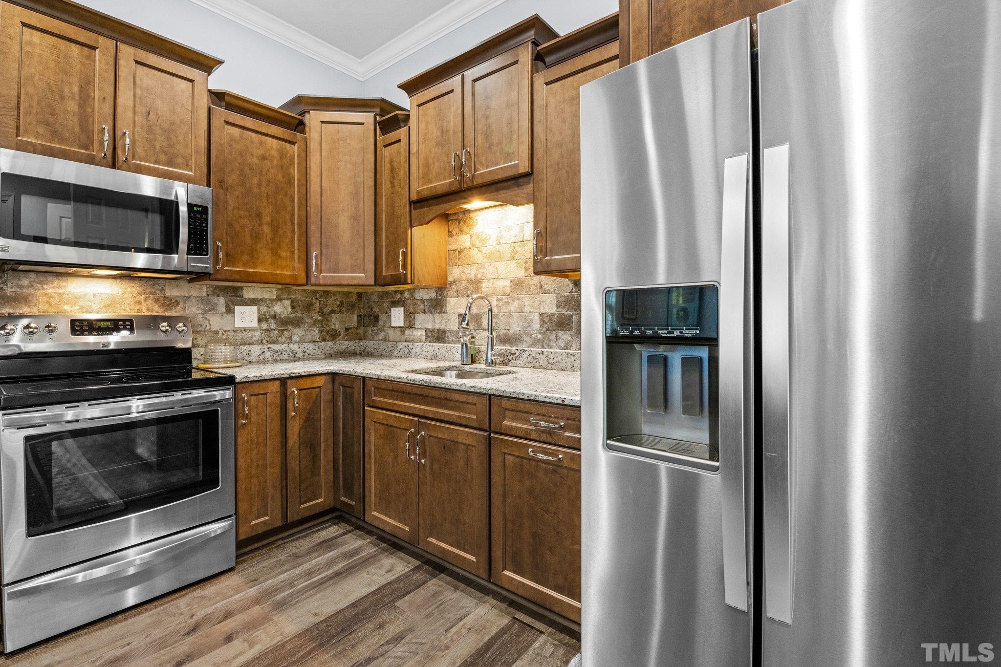 384 Colonial Ridge Drive Pittsboro, NC 27312 - Photo 20 of 47 a kitchen with stainless steel appliances a stove sink and microwave