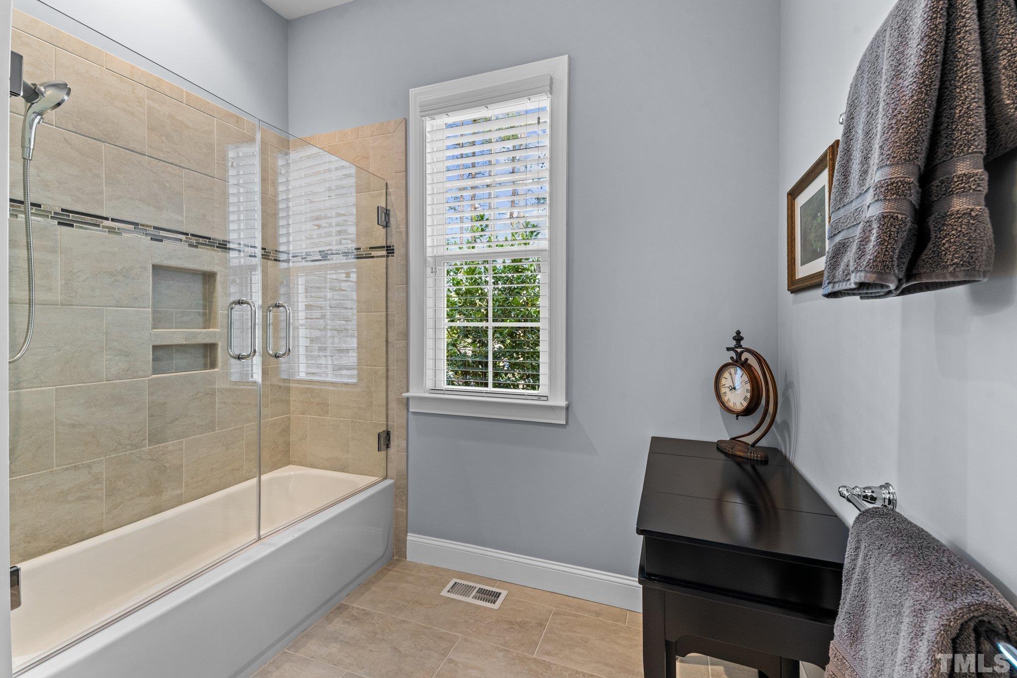 384 Colonial Ridge Drive Pittsboro, NC 27312 - Photo 21 of 47 a bathroom with a bathtub a shower and a window