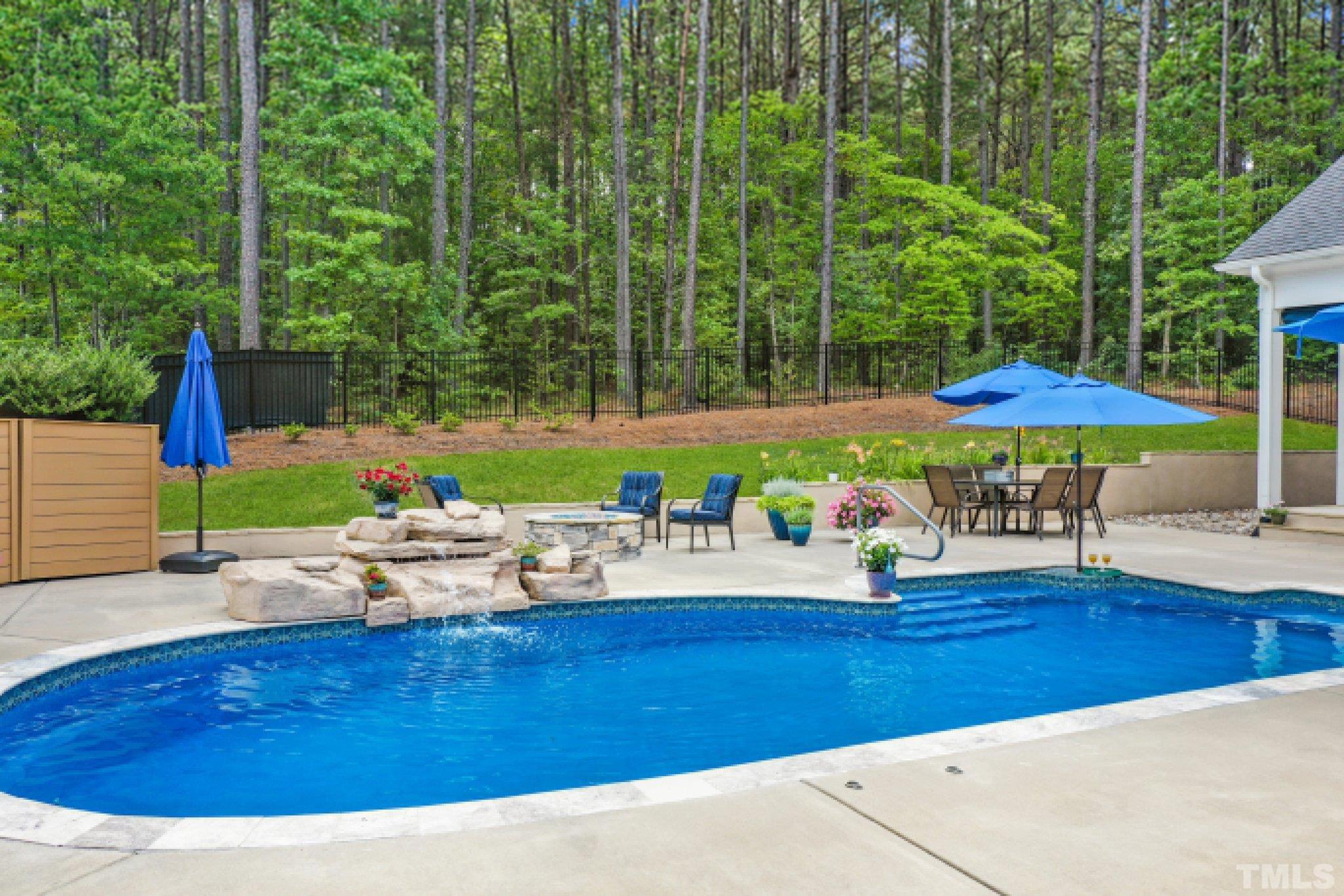 384 Colonial Ridge Drive Pittsboro, NC 27312 - Photo 30 of 47 a view of a backyard with table and chairs under an umbrella