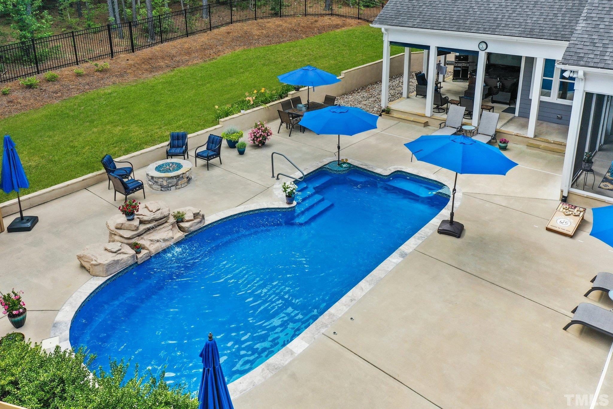 384 Colonial Ridge Drive Pittsboro, NC 27312 - Photo 31 of 47 a view of a backyard with table and chairs under an umbrella with wooden fence