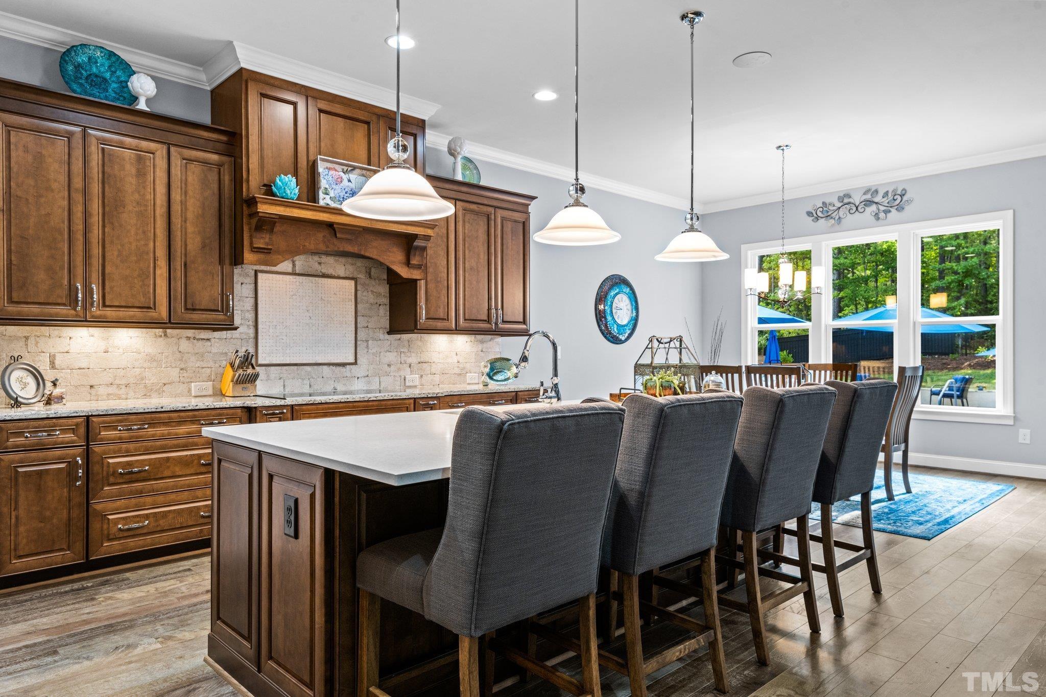 384 Colonial Ridge Drive Pittsboro, NC 27312 - Photo 8 of 47 a kitchen with a dining table chairs sink and cabinets