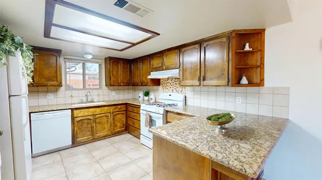 a kitchen with stainless steel appliances granite countertop wooden cabinets a sink and dishwasher