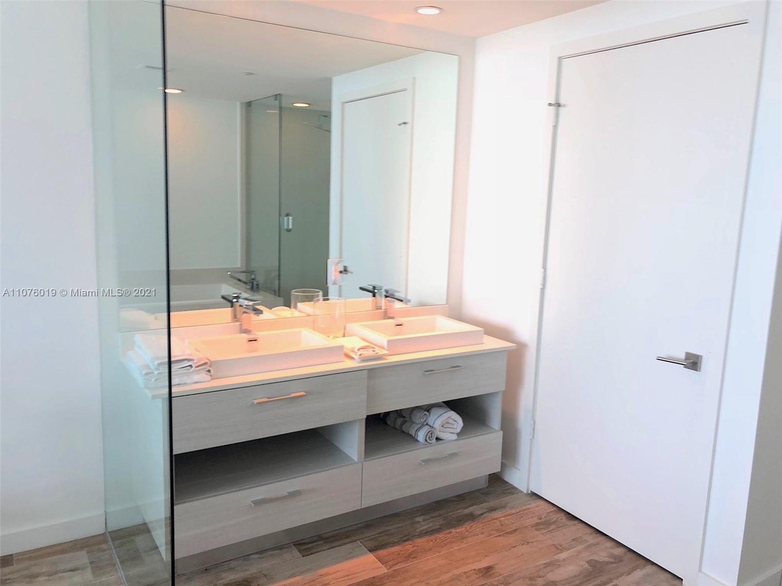 650 Northeast 32nd Street, Unit 4103 Miami, FL 33137 - Photo 19 of 44 a bathroom with a sink and a mirror