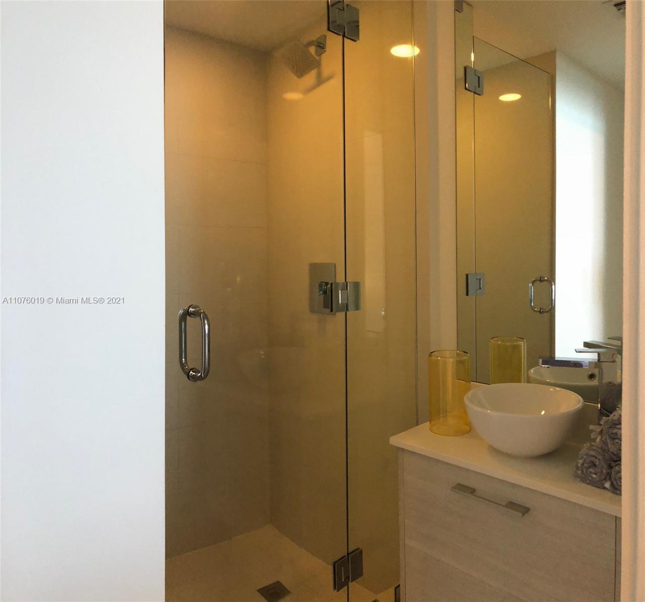 650 Northeast 32nd Street, Unit 4103 Miami, FL 33137 - Photo 5 of 44 a bathroom with a shower sink and mirror