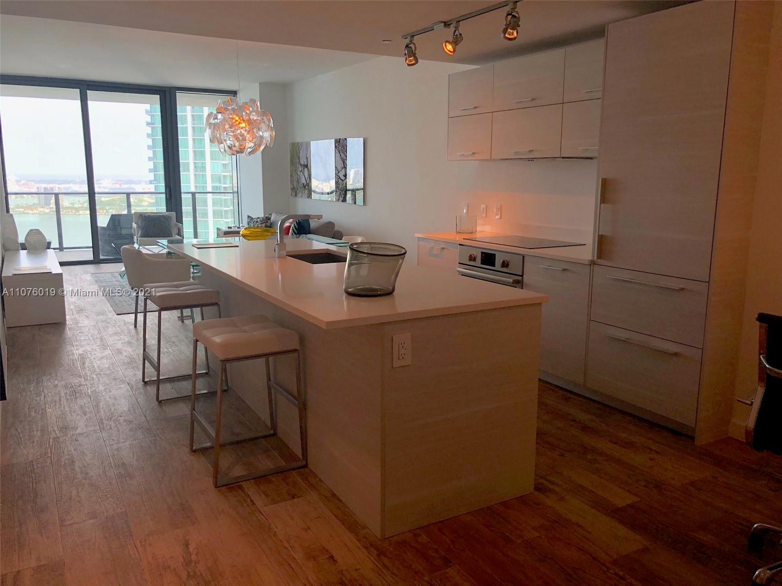 650 Northeast 32nd Street, Unit 4103 Miami, FL 33137 - Photo 6 of 44 a kitchen with sink cabinets and wooden floor