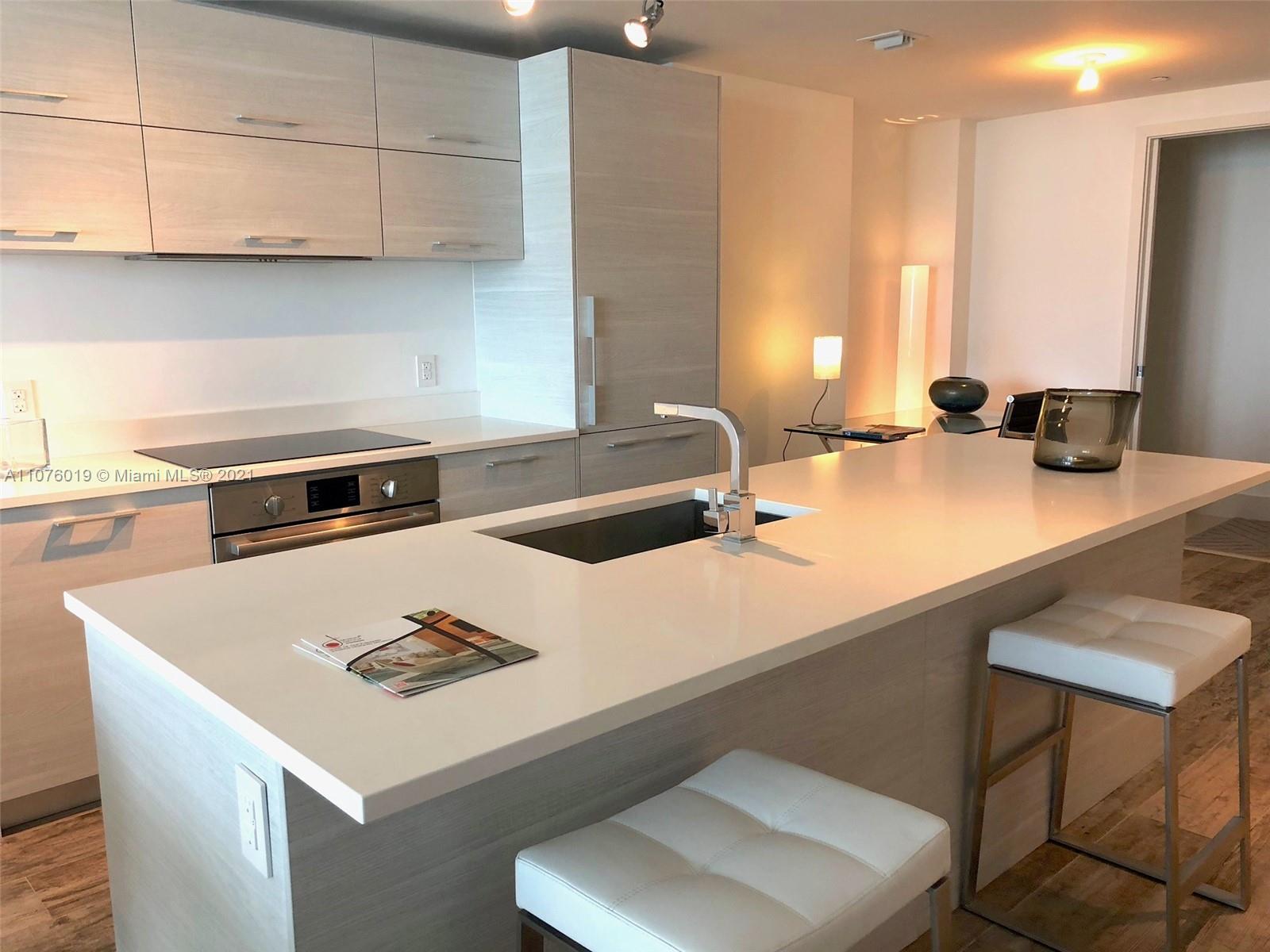 650 Northeast 32nd Street, Unit 4103 Miami, FL 33137 - Photo 8 of 44 a kitchen with a sink a stove and a refrigerator