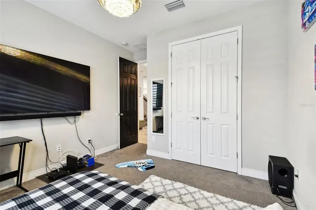 a view of a dining room and livingroom with furniture wooden floor a chandelier