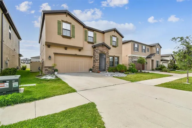 a front view of a house with a yard and garage