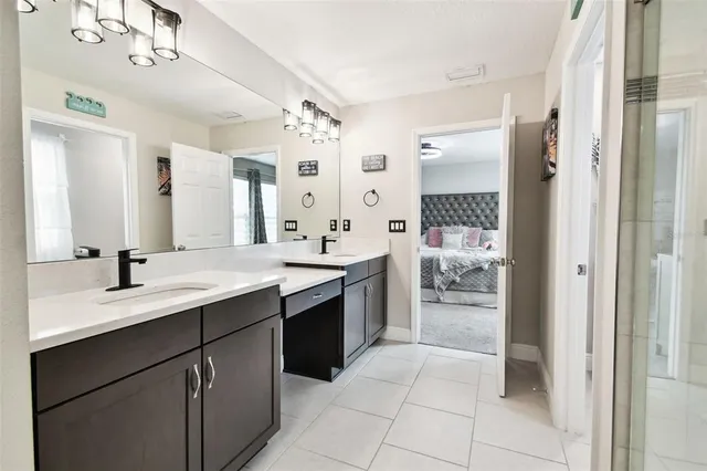 a view of a white house next to a yard with potted plants