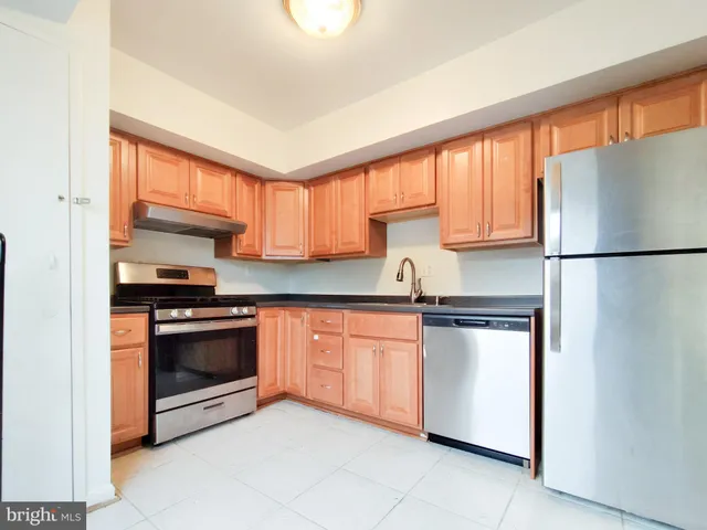 a kitchen with stainless steel appliances granite countertop a refrigerator sink and stove