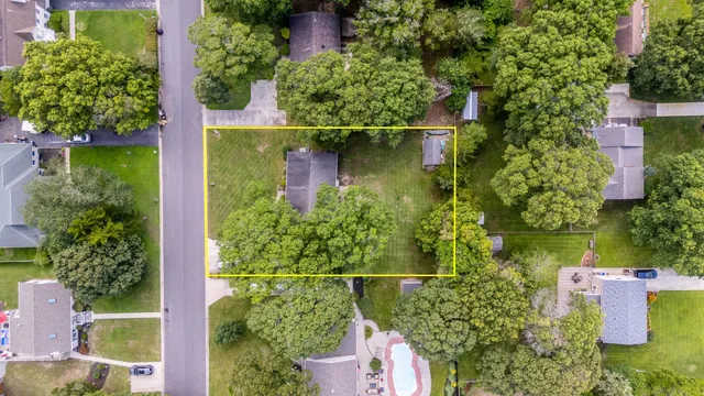 an aerial view of a house with a yard and lake view