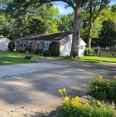 a front view of a house with a yard and trees