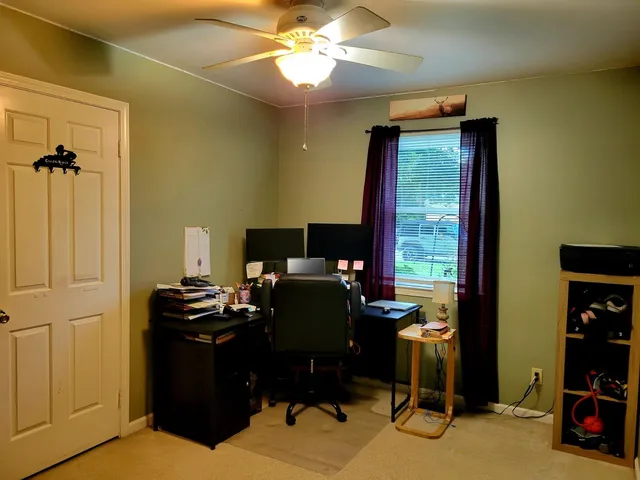 a view of a workspace with furniture and a window
