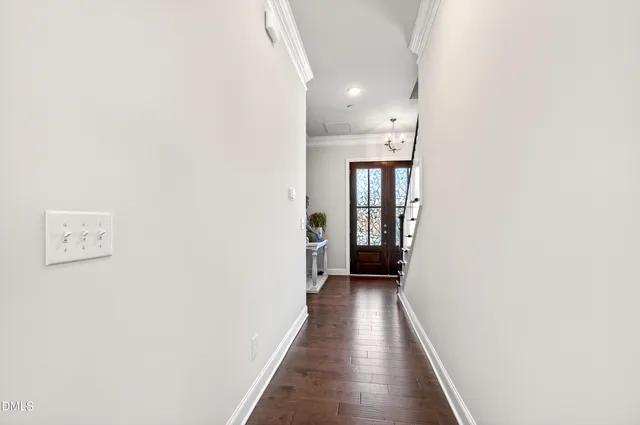 a view of a hallway with wooden floor and a bathroom