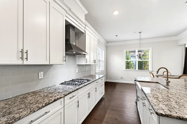 a kitchen with granite countertop a stove a sink and a granite counter tops
