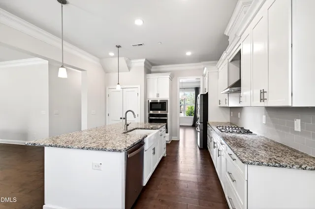 a large kitchen with kitchen island granite countertop a large counter top and stainless steel appliances
